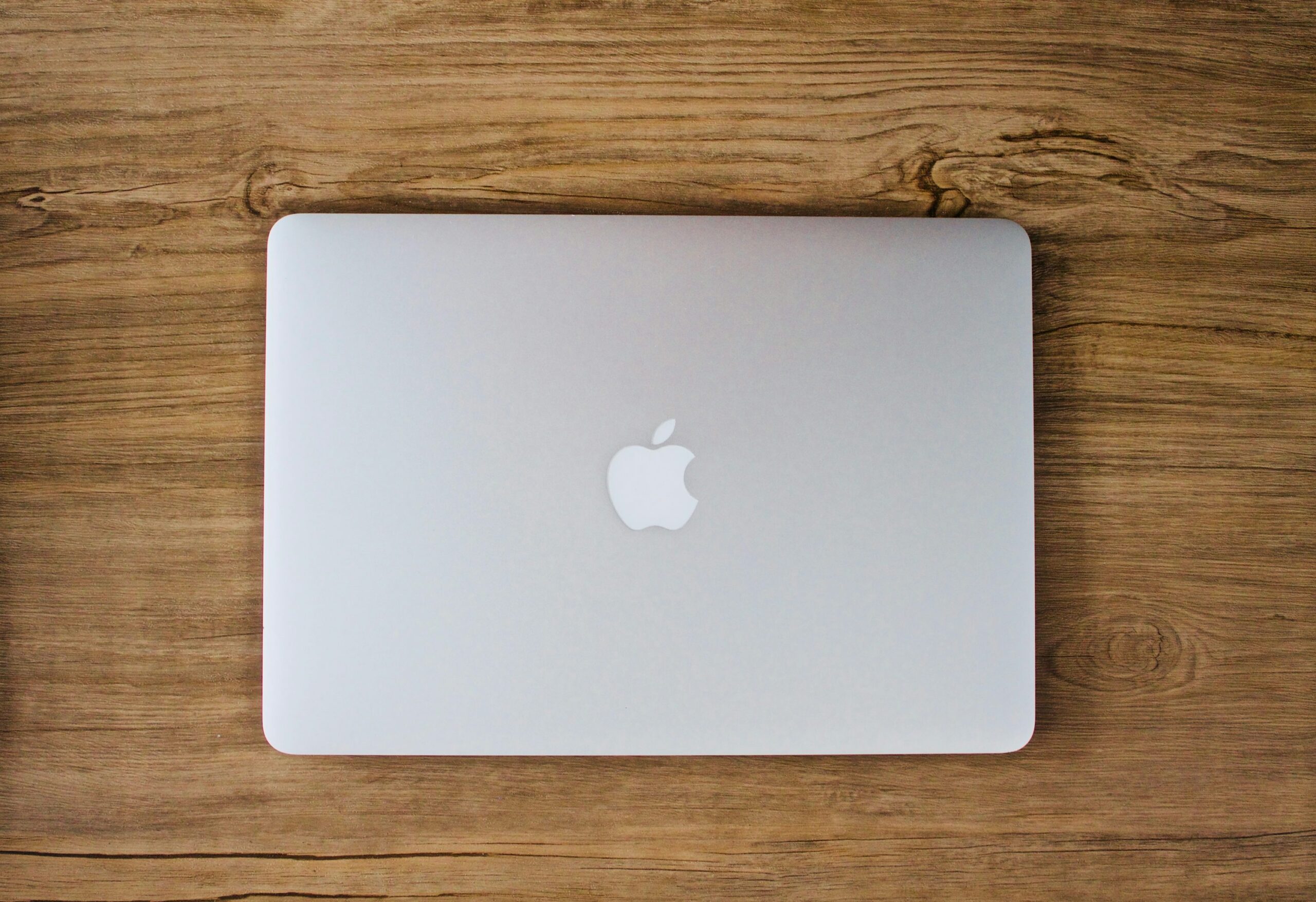 persona tomando una foto de MacBook plateado sobre la mesa